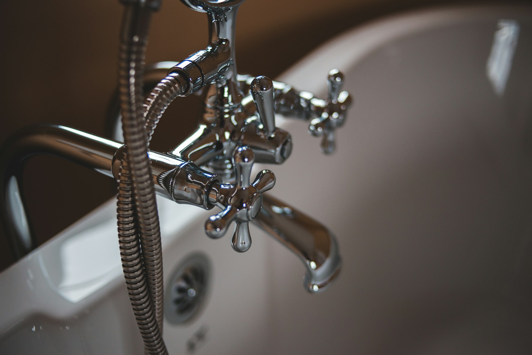 Residential plumbing professional working beneath a sink
